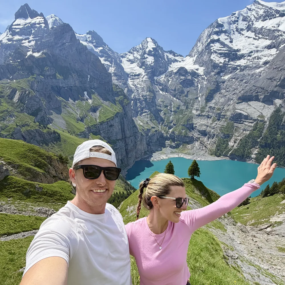 Megs and Pat taking a selfie above a turquoise alpine lake
